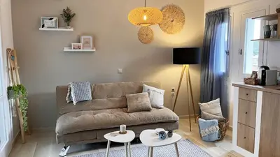 a living room with a couch and two tables at Kalimera Kalyves Apartment in Kalyves