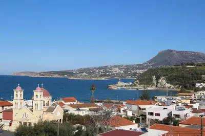 a view of a town with a church and the water at Kalimera Kalyves Apartment in Kalyves