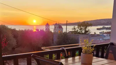 a view of a sunset from a balcony with a table at Kalimera Kalyves Apartment in Kalyves