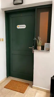 a green garage door with a sticker on it at Kalimera Kalyves Apartment in Kalyves