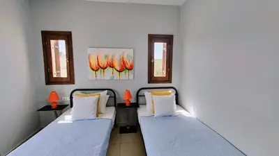 two beds in a room with two windows at Bellavista Panorama Darmarochori in Darmarochori