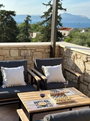a patio with two chairs and a table with wine glasses at Villa Elpida Aspro in Koprána