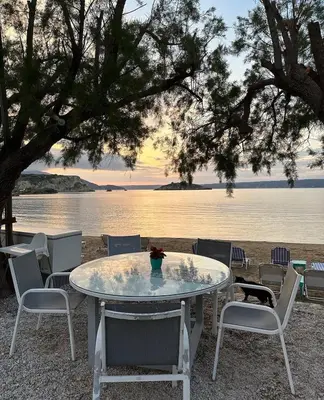 a table and chairs with a view of the water at Villa Elpida Aspro in Koprána