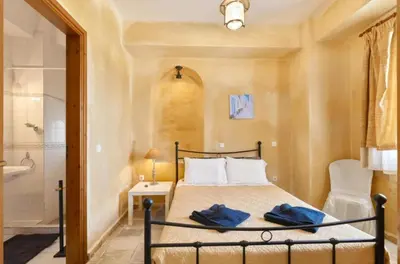 a bedroom with a bed and a bathroom with a shower at Elaiona Country Home in Xamoudhokhórion