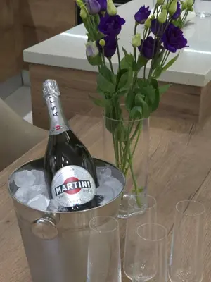 a bottle of champagne in a bucket with flowers at Breeze Apartment in Chania Town