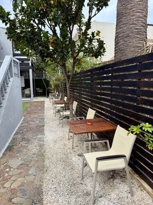a row of wooden tables and chairs next to a fence at Dom Suites in Aghii Apostoli