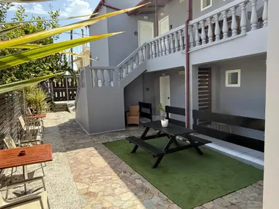 a patio with a picnic table and a staircase at Dom Suites in Aghii Apostoli