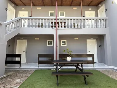 a patio with a bench and a table and stairs at Dom Suites in Aghii Apostoli