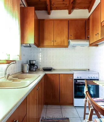 a kitchen with wooden cabinets and a white stove top oven at Alkis Hideaway in Kissamos