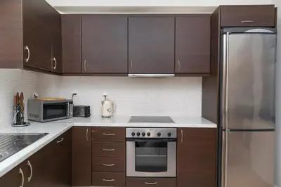 a kitchen with wooden cabinets and stainless steel appliances at Villa Kimi -New listing with sea views! in Kalyves
