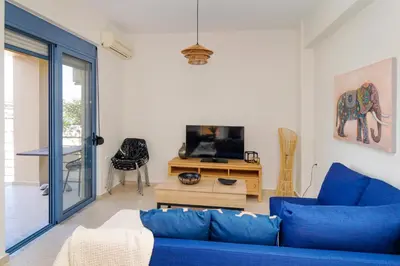 a living room with a blue couch and a tv at Villa Kimi -New listing with sea views! in Kalyves