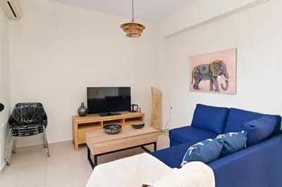 a living room with a blue couch and a tv at Villa Kimi -New listing with sea views! in Kalyves