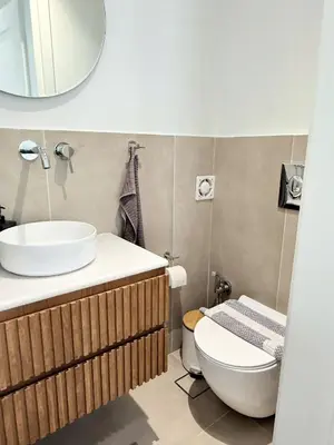 a bathroom with a sink and a toilet and a mirror at Azure Loft - 3min walk to beach, 10min to Old Town in Chania Town