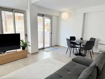 a living room with a couch and a table at Azure Loft - 3min walk to beach, 10min to Old Town in Chania Town