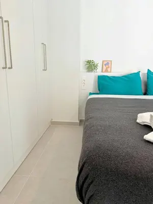 a bedroom with a bed with blue and white cabinets at Azure Loft - 3min walk to beach, 10min to Old Town in Chania Town