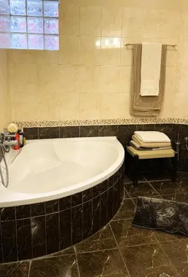a bath tub in a bathroom with a black tile floor at La Casa di Corina in Kato Daratso