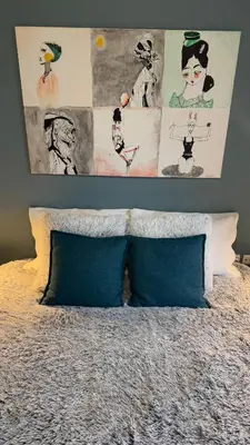 a bed with two pillows and pictures on the wall at La Casa di Corina in Kato Daratso