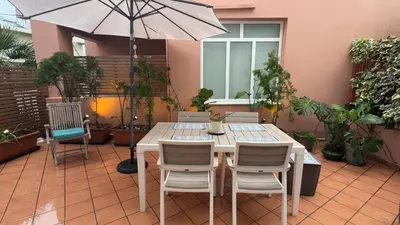 a table with chairs and an umbrella on a patio at La Casa di Corina in Kato Daratso