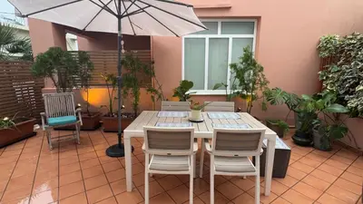 a table with chairs and an umbrella on a patio at La Casa di Corina in Kato Daratso