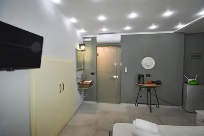 a room with a bathroom with a sink and a television at Vasiliki Venetian suites in Chania Town