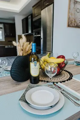 a table with a bottle of wine and a bowl of fruit at AITHRA seaside in Arónion