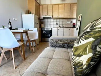 a living room with a couch and a table and a kitchen at Son of the Beach Apartment - 20sec walk to beach in Chania Town