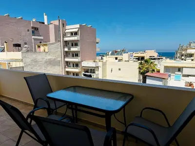 a table and chairs on a balcony with a view at Son of the Beach Apartment - 20sec walk to beach in Chania Town