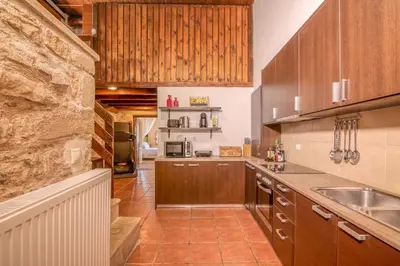 a kitchen with wooden cabinets and a counter top at Villa Dimmare by PosarelliVillas in Kissamos