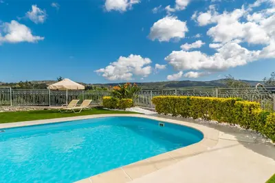 a swimming pool in a yard with a fence at Villa Faye by PosarelliVillas in Metókhion