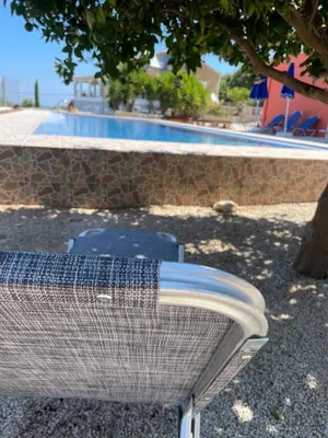 a metal object sitting in front of a swimming pool at Dans une villa avec piscine privée, calme, proche des plages, vues mer et montagnes in Tsivarás