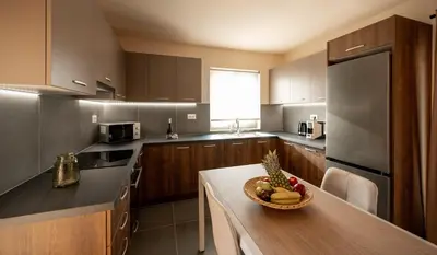 a kitchen with a bowl of fruit on a table at Giannoulis Ele Villas in Skoutelónas