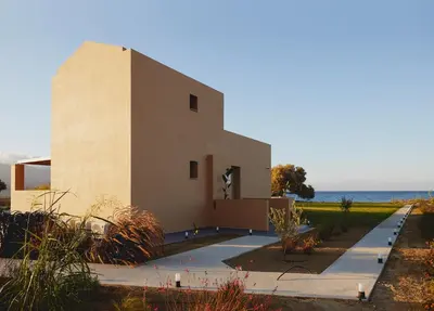a building with the ocean in the background at Giannoulis Ele Villas in Skoutelónas