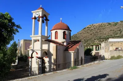 a building with a tower with a clock on it at Village Villa Marika Drapanias in Drapaniás