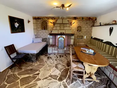 a living room with a table and a fireplace at Village Villa Marika Drapanias in Drapaniás