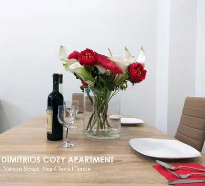 a table with a vase of red roses and a bottle of wine at Dimitrios Cozy Apartment in Chania Town