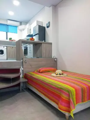 a bedroom with a bed with a colorful striped blanket at Dimitrios Cozy Apartment in Chania Town