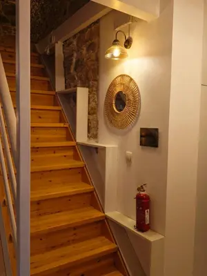 a staircase in a house with wooden floors at Restored traditional stone House-Magazi in Sirílion