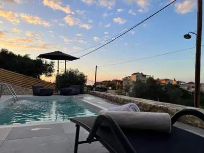 a swimming pool with a chair and an umbrella at Villa Maria in Stalos