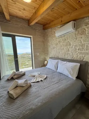 a bedroom with a bed with towels and a window at Villa Maria in Stalos