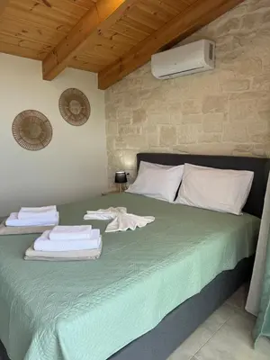 a bedroom with a green bed with towels on it at Villa Maria in Stalos