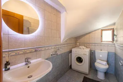 a bathroom with a sink and a washing machine at Dimosthenis by Vintage Travel in Stalos