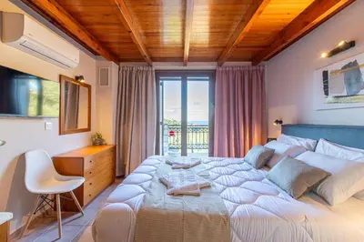 a bedroom with a large bed with a desk and a window at Dimosthenis by Vintage Travel in Stalos