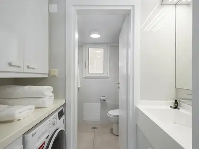 a white bathroom with a washing machine in it at Amelia Luxury Living Mantaka in Chania Town