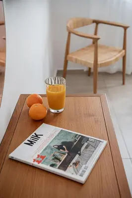 a magazine and a glass of orange juice on a table at Amelia Luxury Living Mantaka in Chania Town