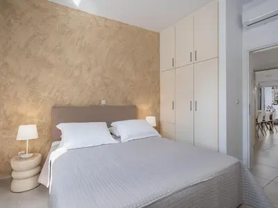 a bedroom with a large white bed with white walls at Amelia Luxury Living Mantaka in Chania Town