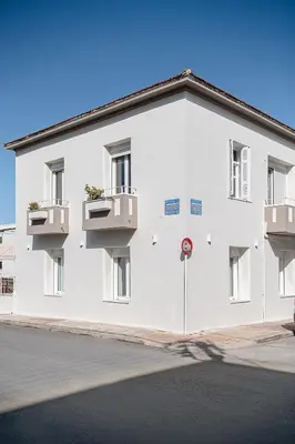 a white building with two balconies on a street at Amelia Luxury Living Mantaka in Chania Town