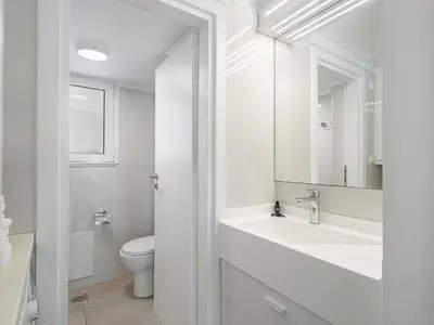 a white bathroom with a sink and a toilet at Amelia Luxury Living Mantaka in Chania Town