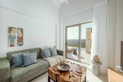 a living room with a green couch and a table at Ethereal White Villas in Gramvousá