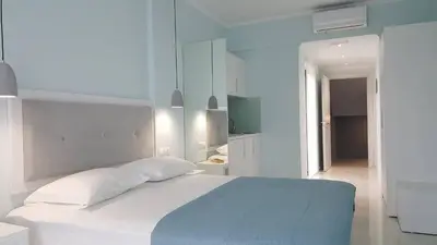 a white bedroom with a bed and a television at Mear Luxury Holiday Homes - Cretan Sunny Gems in Kountoura Selino