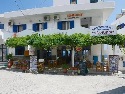a building with tables and chairs in front of it at Tarra in Agia Roumeli